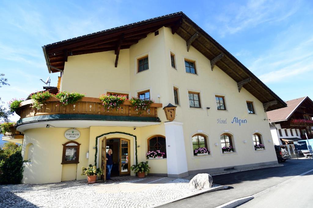 un grand bâtiment jaune avec un balcon dans une rue dans l'établissement Hotel Alpin, à Ehrwald