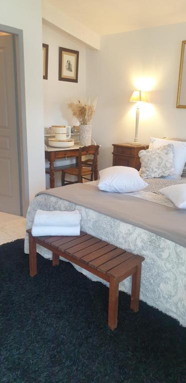 1 dormitorio con 2 camas y banco de madera en Chambre Maddy, en Parranquet