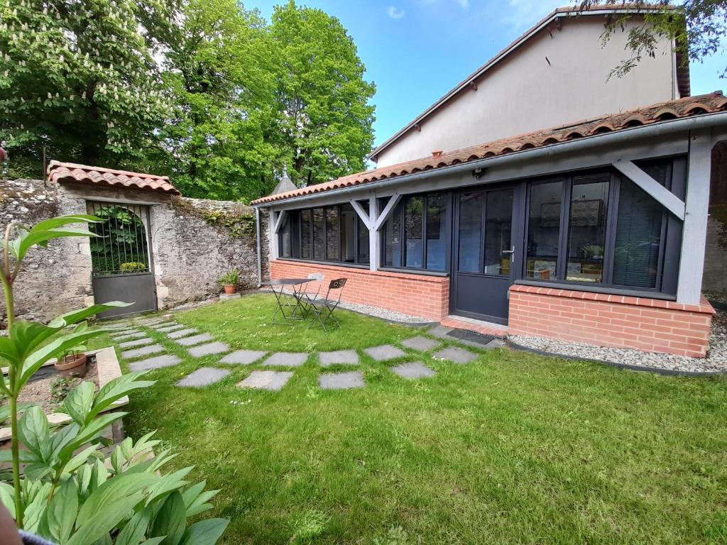 a house with a yard with a bench in the grass at L'Inattendu in Saint-Sébastien-sur-Loire