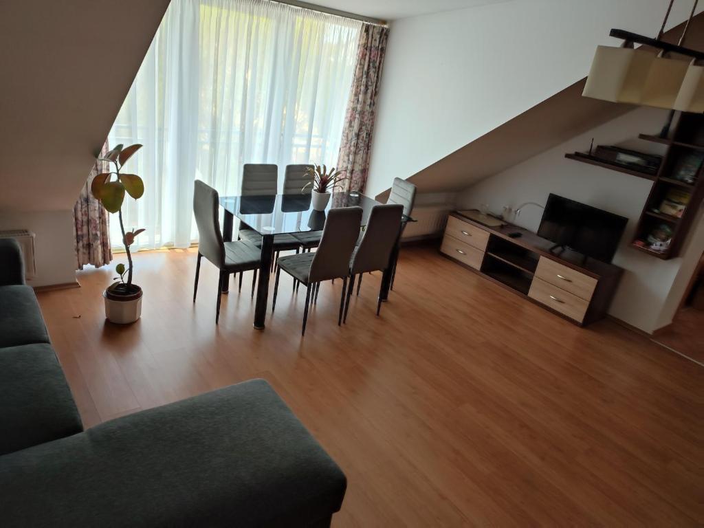 uma sala de estar com uma mesa de jantar e cadeiras em LARIX Apartman em Sárvár