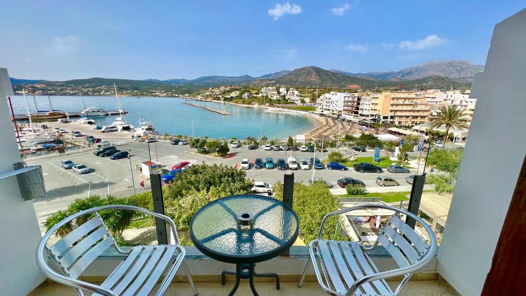a balcony with two chairs and a view of a harbor at Atlantis Hotel in Agios Nikolaos