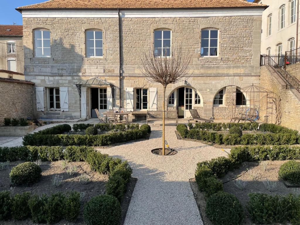 a building with a courtyard with bushes in front of it at L'Orangerie in Neufchâteau