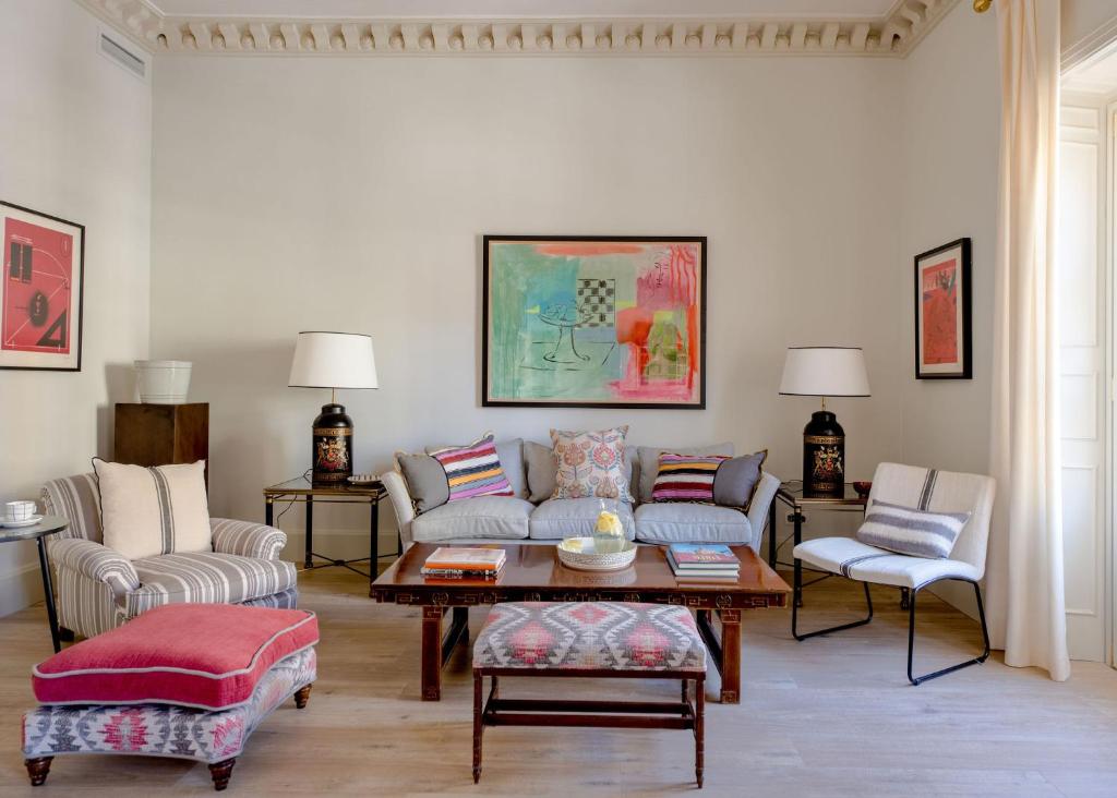 uma sala de estar com um sofá, cadeiras e uma mesa em Hommyhome Cuesta del Rosario em Sevilha