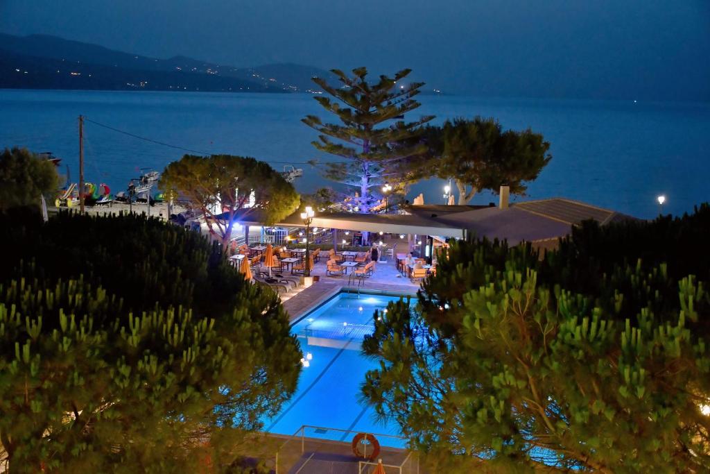 a swimming pool with a view of the water at night at Valais Hotel in Alikanas
