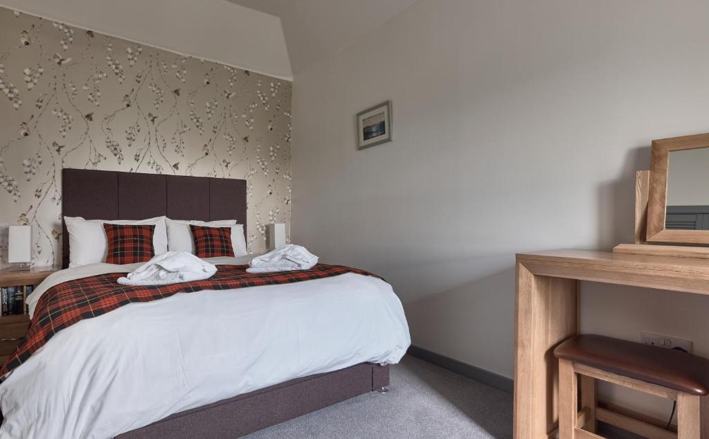 ein Schlafzimmer mit einem großen Bett in einem Zimmer in der Unterkunft Monkstadt Room 21 - MacQueen Cottage in Portree