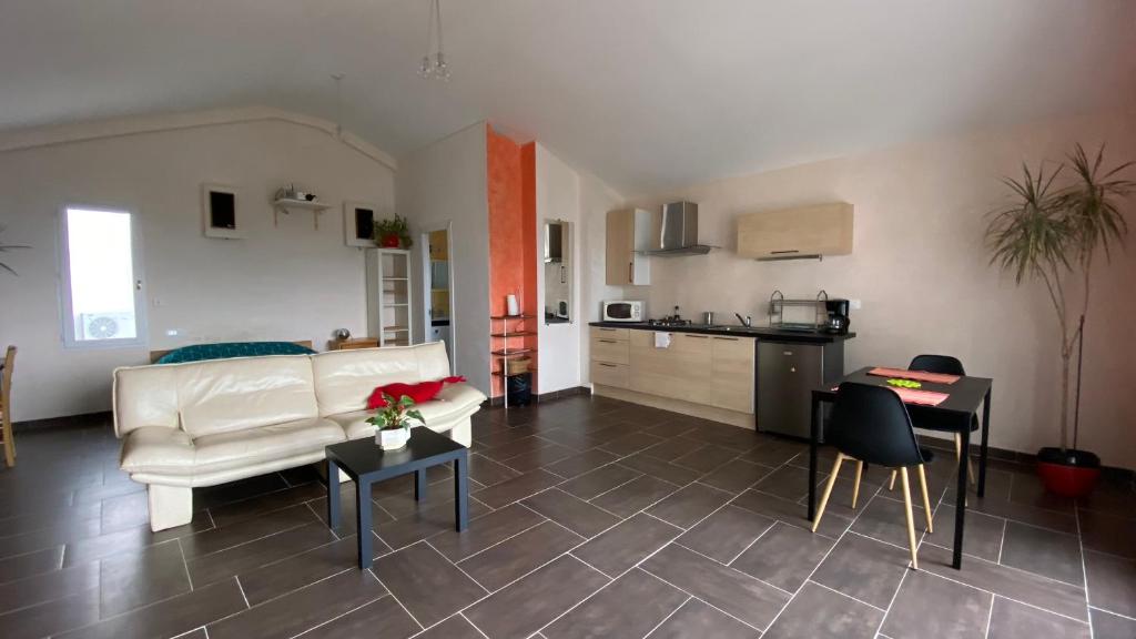 サン・ジェリー・デュ・フェスにあるGrand studio dans villa au calme avec vuesのリビングルーム(白いソファ付)、キッチンが備わります。