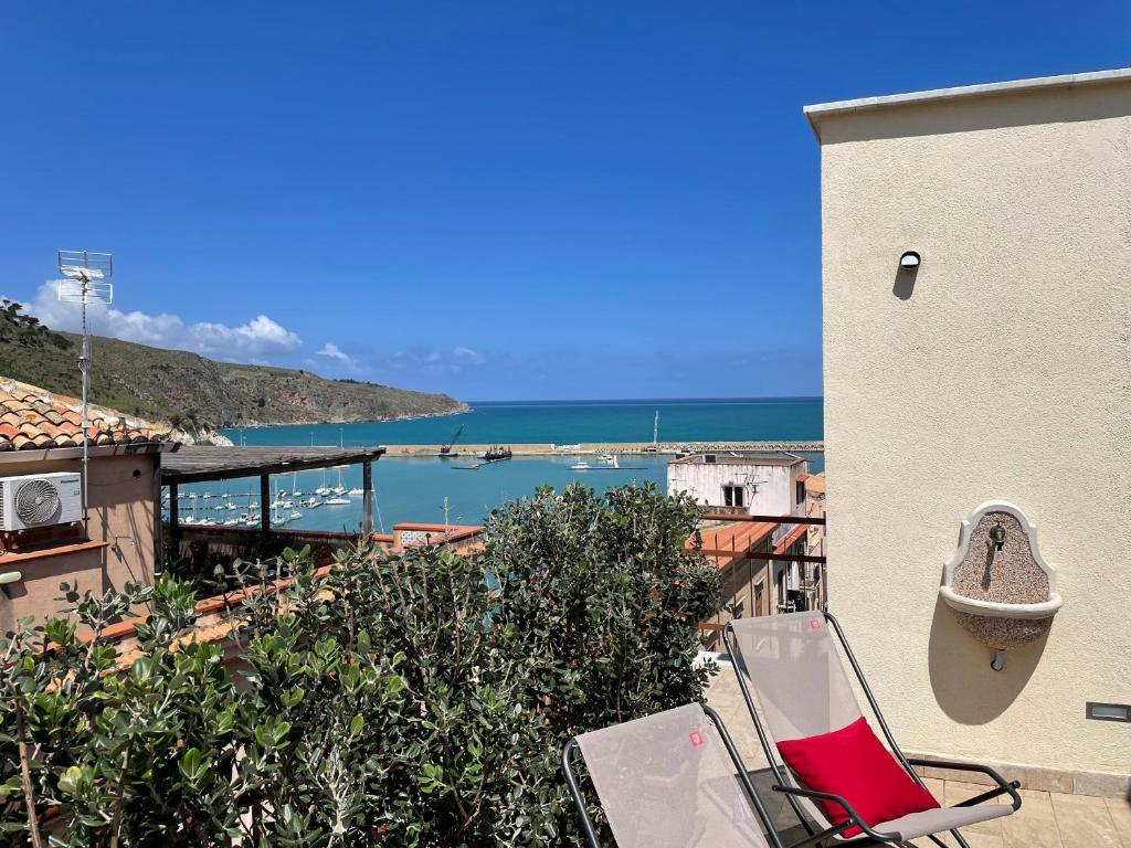 a balcony with a chair and a view of the ocean at Suite de la Sicilienne in Castellammare del Golfo