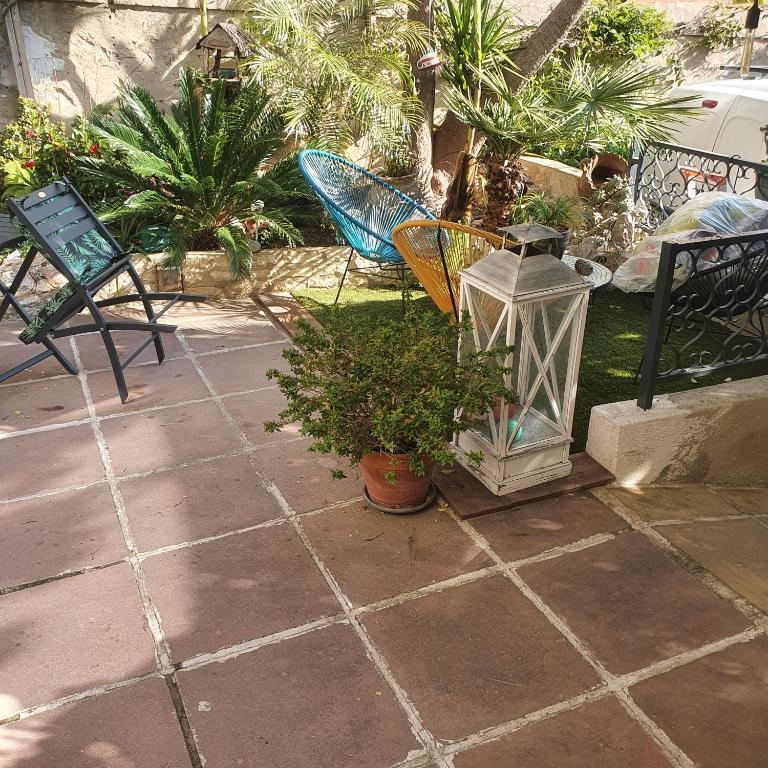 a patio with a lantern and a chair and plants at AndandCo in Marseille