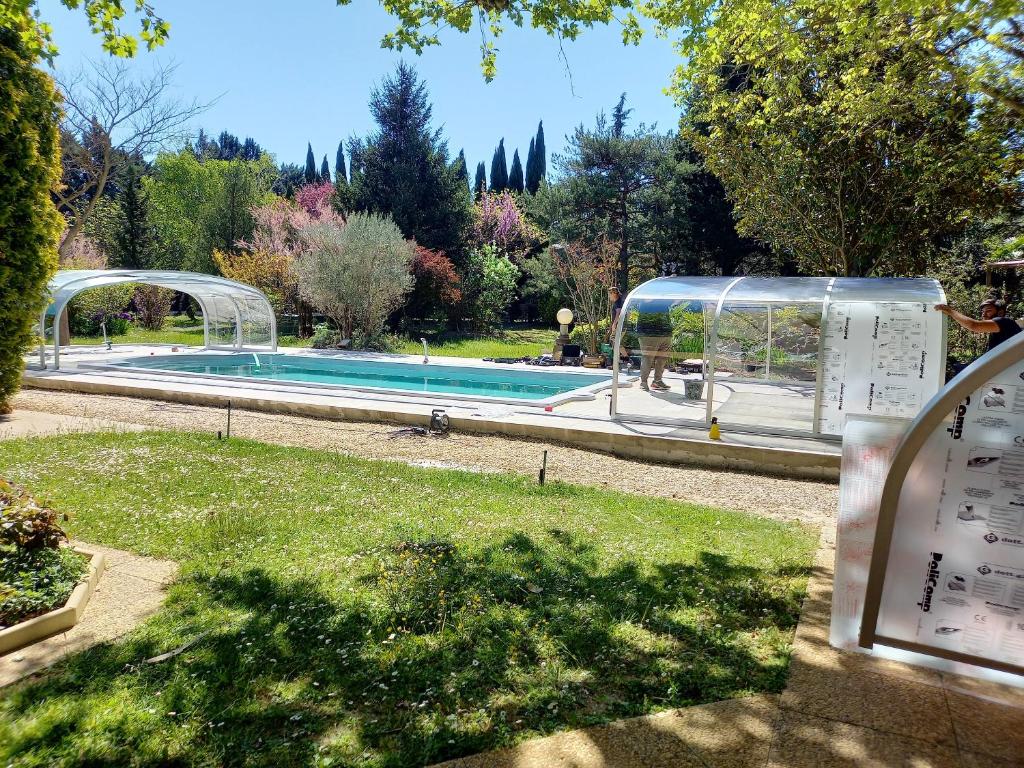 - une piscine dans un jardin à côté d'un parc dans l'établissement Maison Le Thor avec piscine part., au Thor