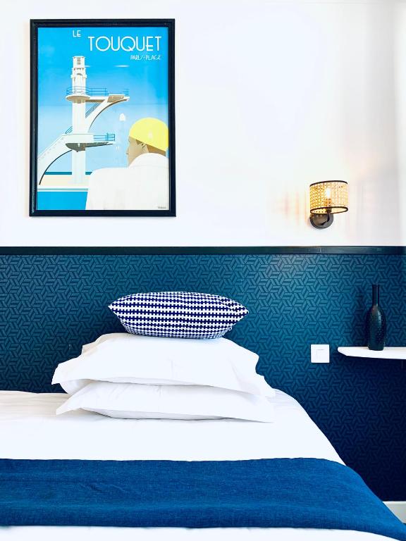 a room with a bed with a poster on the wall at Hôtel Gaspard in Le Touquet-Paris-Plage