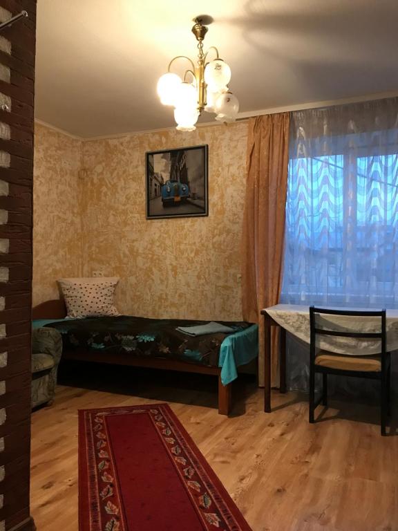 una camera con un letto, un tavolo e una finestra di First Price a Rēzekne