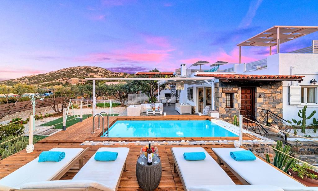 a villa with a swimming pool and a house at Cretan Lodge Heated Pool in Agios Nikolaos
