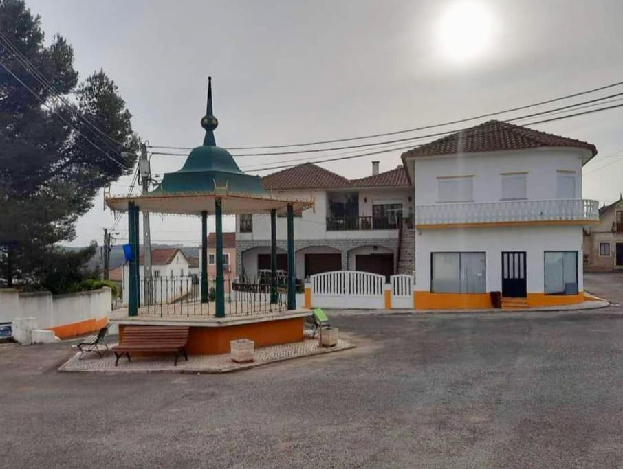 a gazebo with a bench in front of a building at CASA DO NINHO - Entre o Campo e a Praia in Cadaval