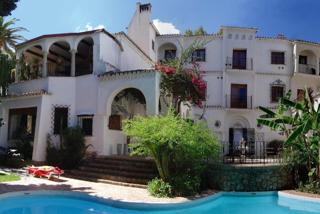 una gran casa blanca con piscina frente a ella en Hotel Residencia Miami en Torremolinos