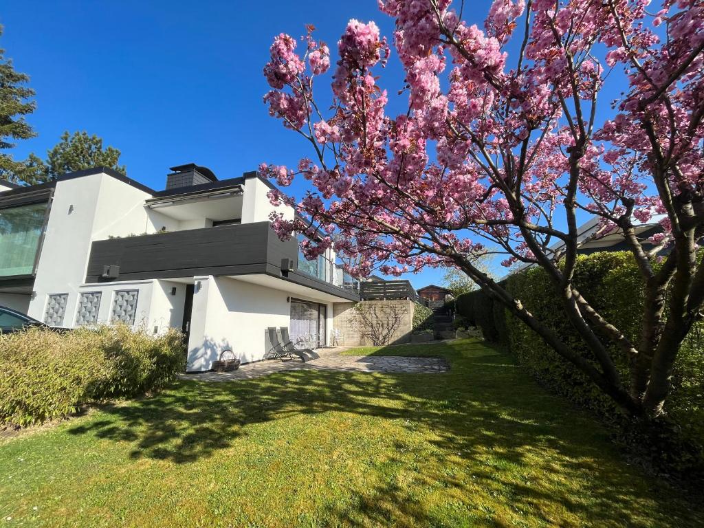 ein Haus mit einem blühenden Baum im Hof in der Unterkunft Ferienwohnung Am Sultmer mit Terrasse und Garten in Northeim