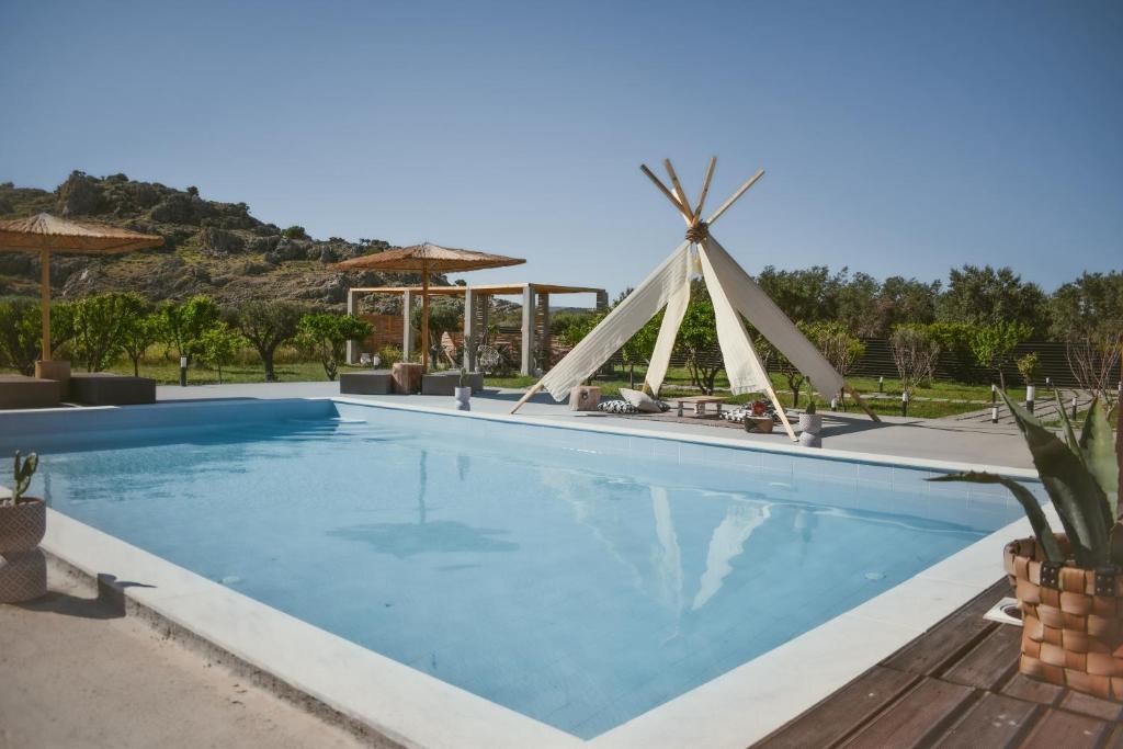 a pool at a resort with a windmill at LA Casa Di Lusso N7 -Adults Only in Kolymbia