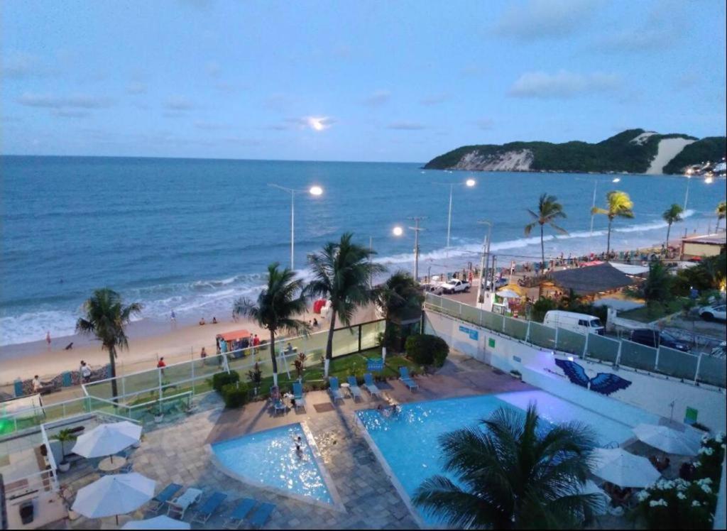 a view of a beach with a swimming pool and the ocean at Ponta Negra Beach Apt 507 in Natal