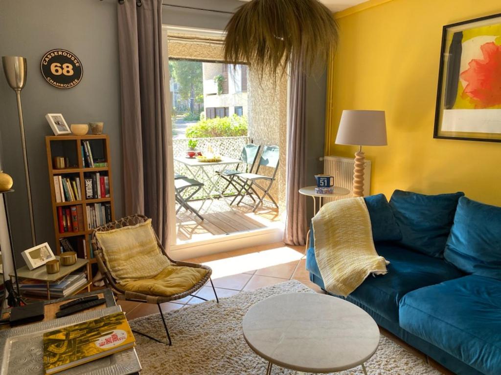 un salon avec un canapé bleu et une table dans l'établissement canaille candelle, à Cassis