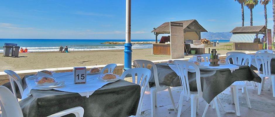 grupa stołów i krzeseł na plaży w obiekcie Apartamento El Palo Beach w Maladze