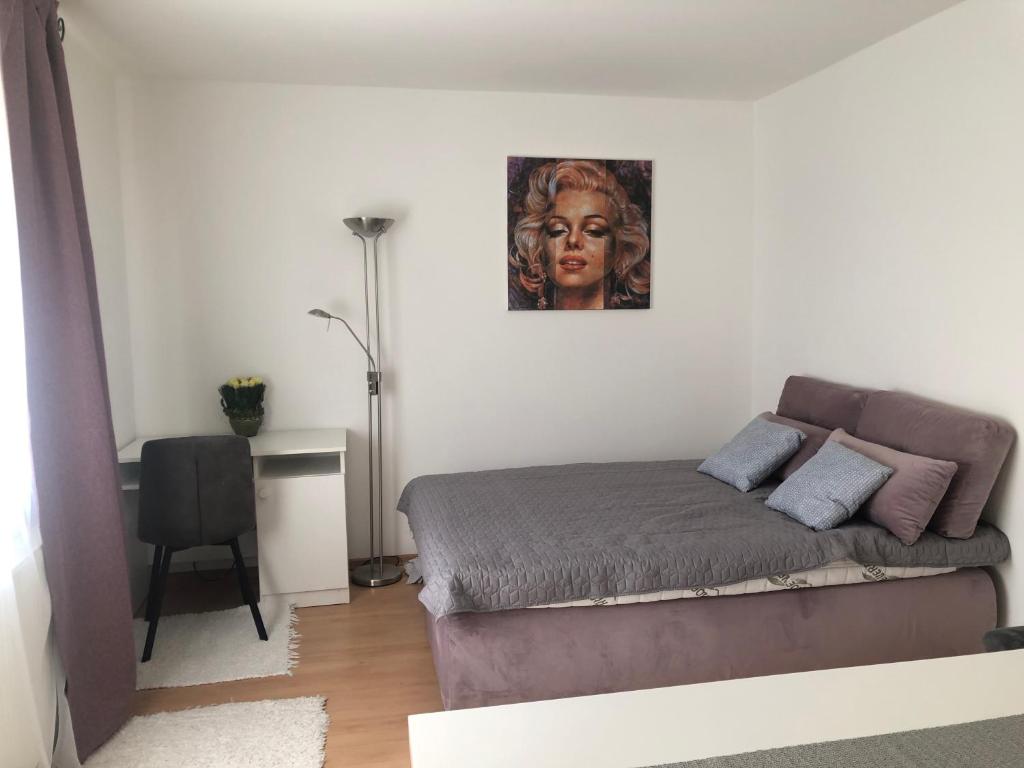 um quarto com uma cama com uma fotografia na parede em Monro Apartment em Hévíz