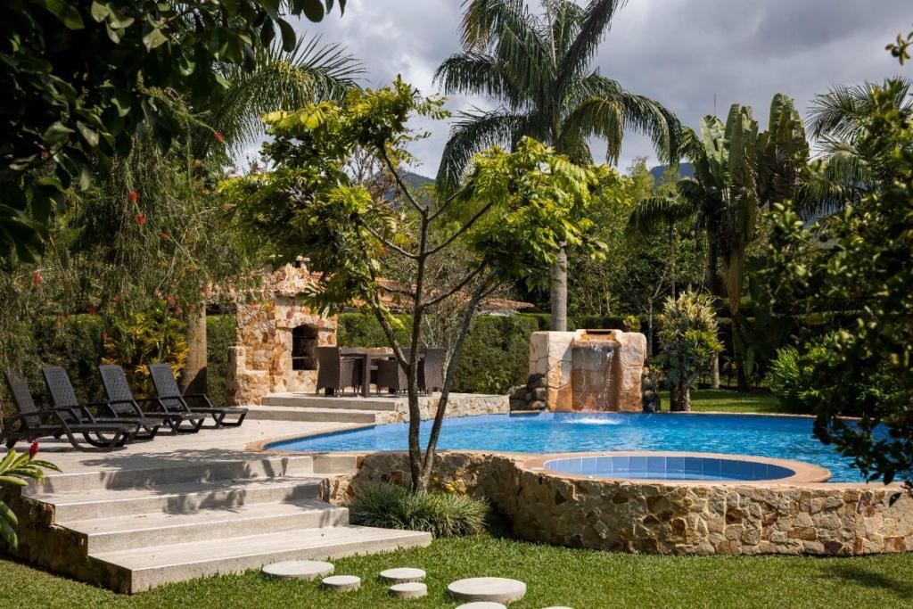 - une piscine dans une cour avec des chaises et un arbre dans l'établissement Espectacular cómoda villa de campo con Piscina, à Papagalleros