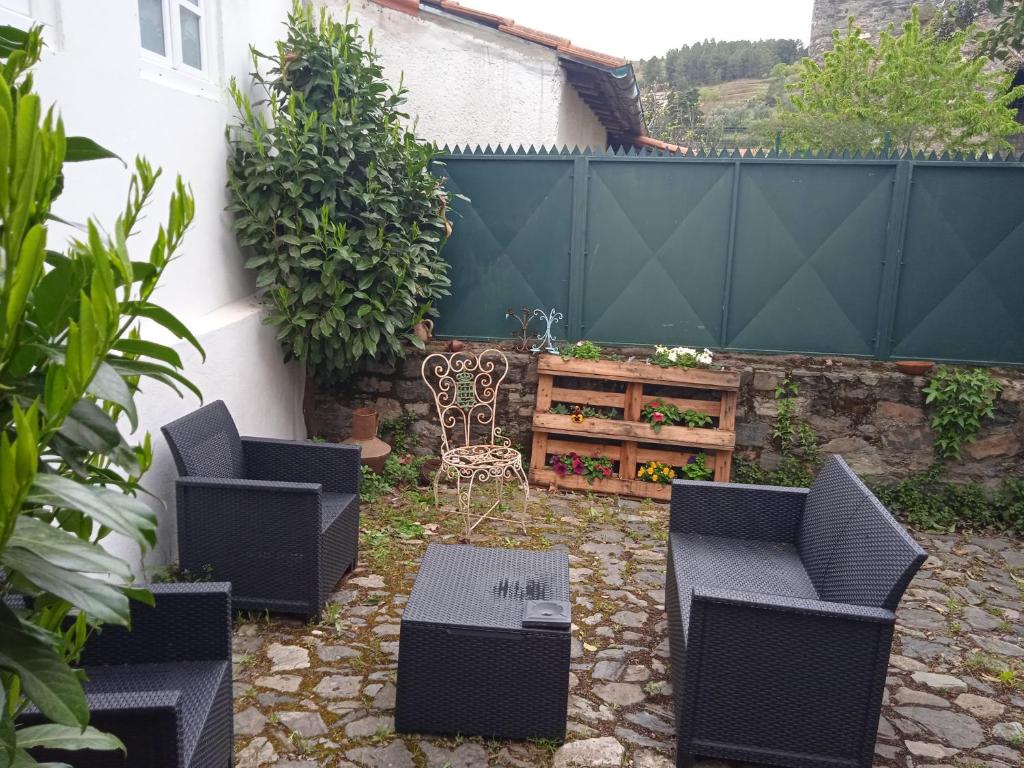 a patio with chairs and a table and a fence at Casa da Porta de Santo António in Bragança