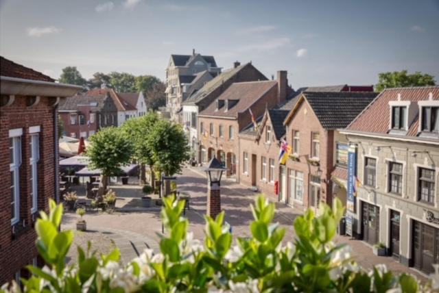 une petite ville avec des bâtiments et une rue fleurie dans l'établissement Gasthuys Rustique, à Arcen