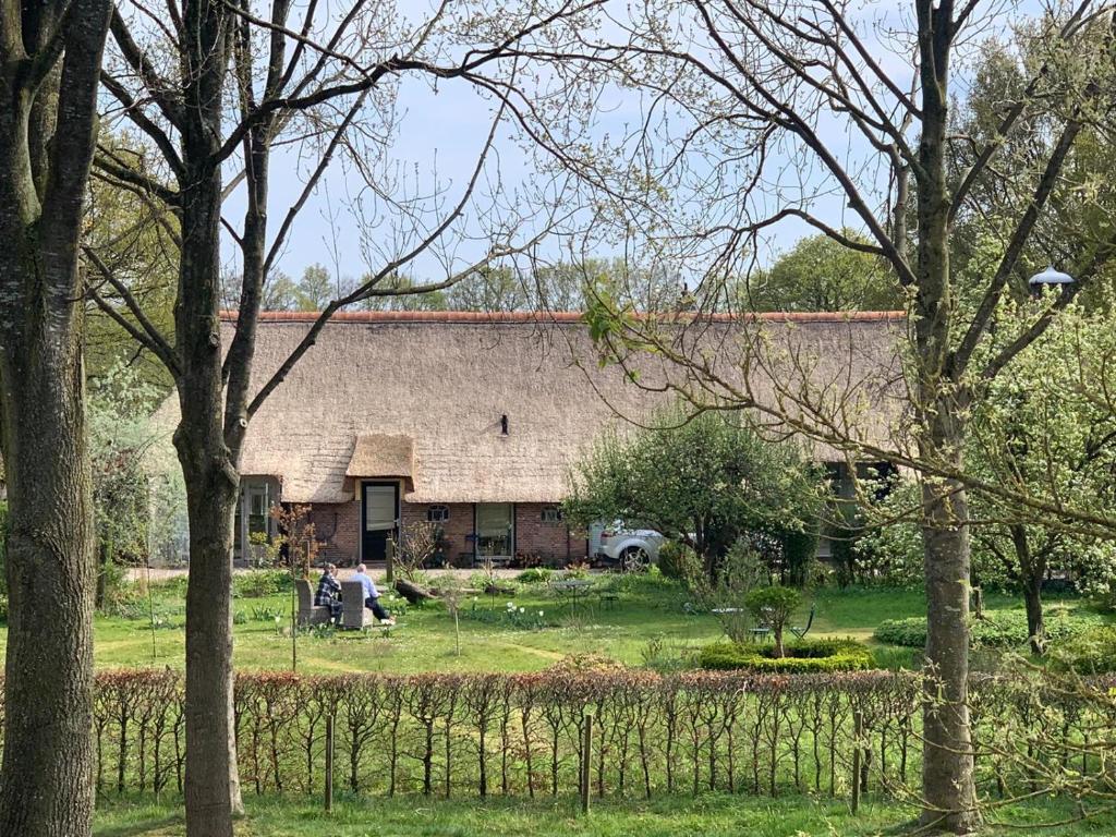 una casa vieja con un montón de árboles delante de ella en Landgoed de Bongel, en De Wijk