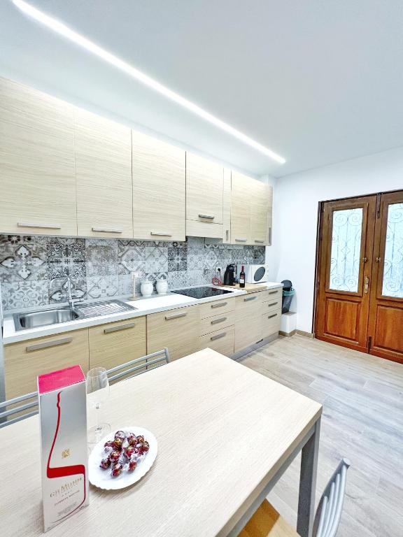 a kitchen with a table with a plate of fruit on it at Luxury Tugurio in Arma di Taggia