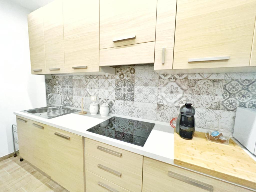 a kitchen with wooden cabinets and a counter top at Luxury Tugurio in Arma di Taggia