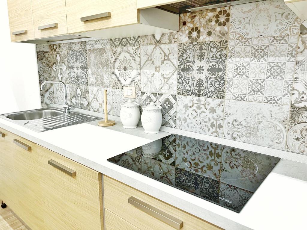 a kitchen with a sink and a tile wall at Luxury Tugurio in Arma di Taggia