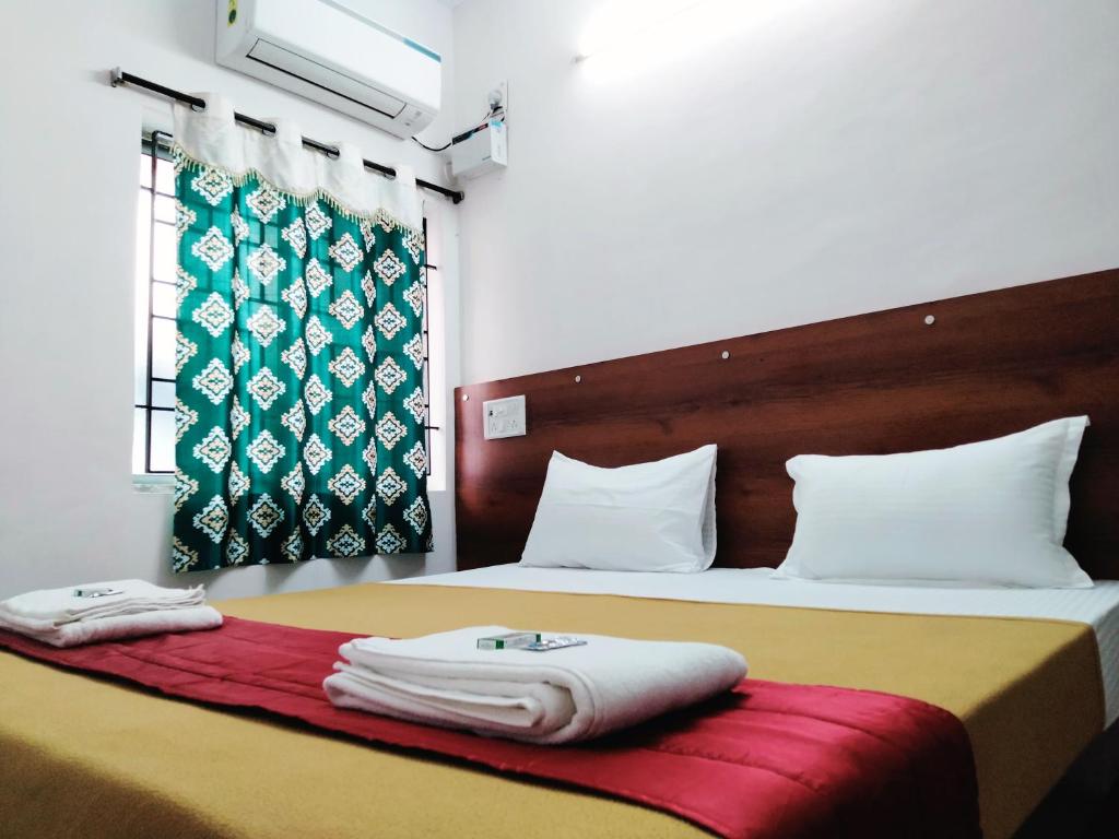 a hotel room with two beds with towels on them at Royal Green Residency Chennai Airport in Chennai