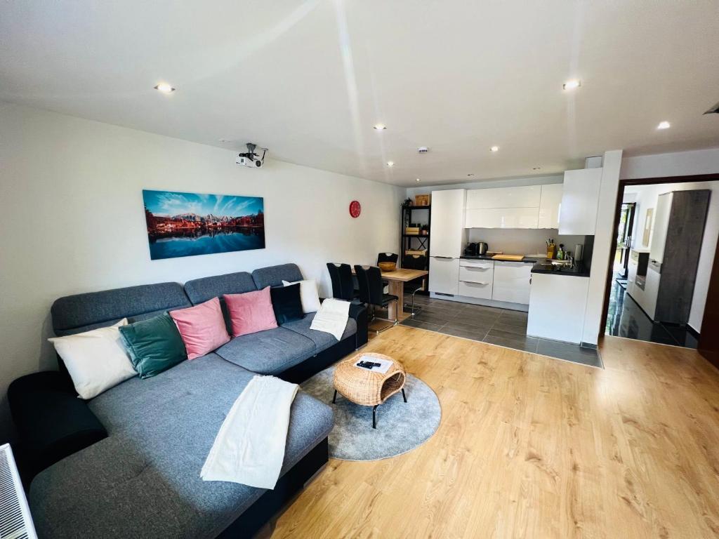 uma sala de estar com um sofá azul e uma cozinha em Modernes Apartment Seefeld and Chill RELAX im Zentrum mit Netflix for free em Seefeld no Tirol