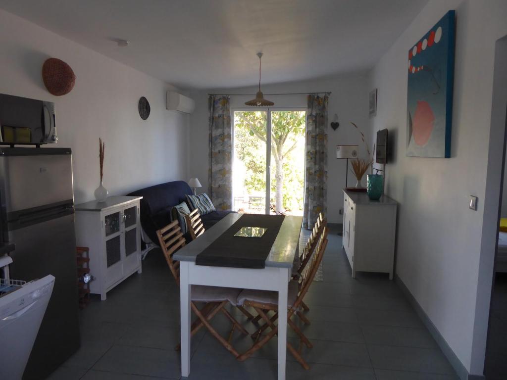 uma cozinha e sala de estar com mesa e cadeiras em Location au calme vue sur le canal du midi et la mer em Portiragnes