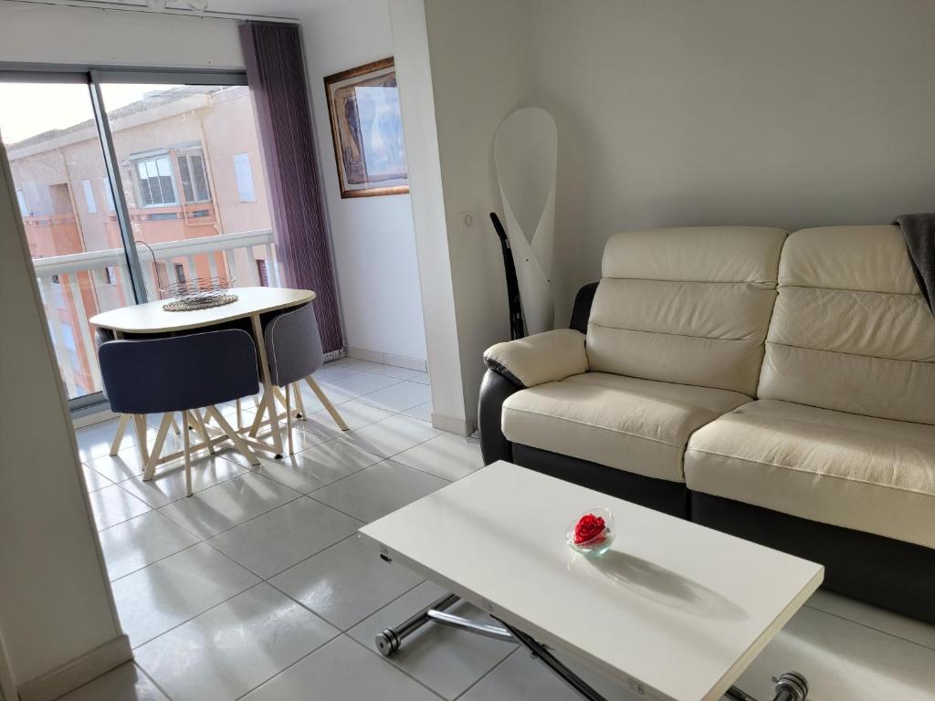 uma sala de estar com um sofá e uma mesa em F2 Saint-Aygulf vue mer, calme, proche Frejus em Saint-Aygulf