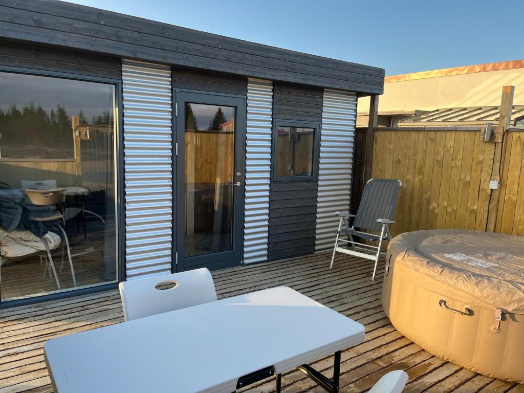 a patio with a table and chairs on a deck at Adorable Tiny House in Reykjavik in Gufunes