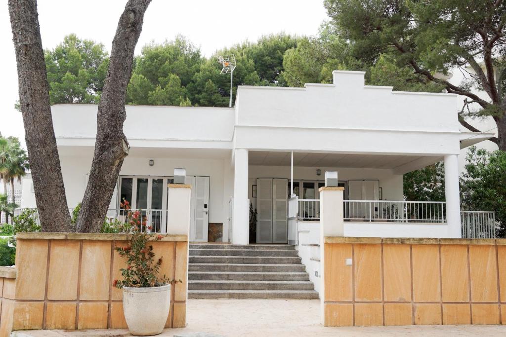 una casa blanca con escaleras y un árbol en Houm Villa Plaza Arosa, en Palma de Mallorca