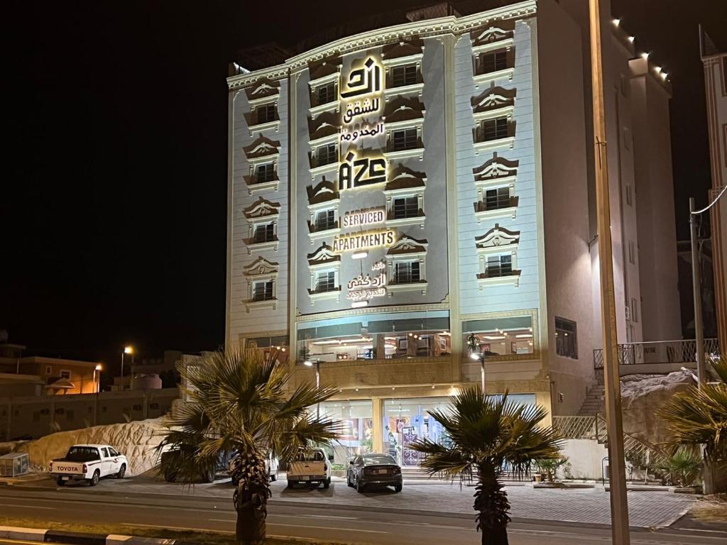 un grande edificio con macchine parcheggiate di fronte di أزد للشقق المخدومة a Tanomah