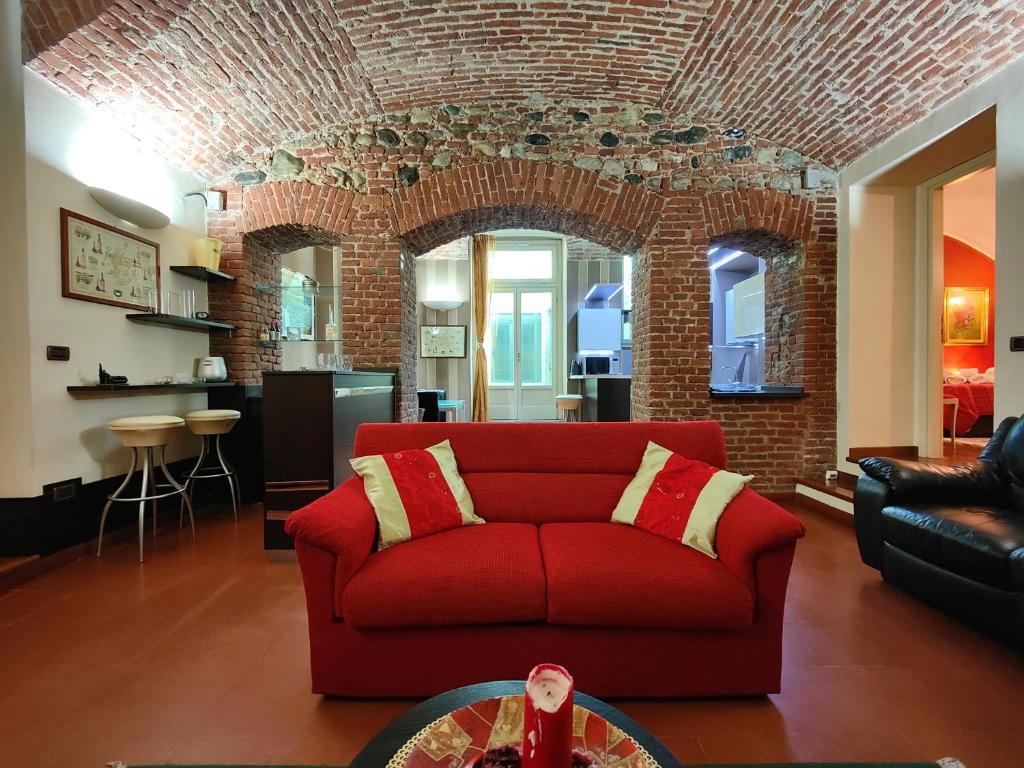 a living room with a red couch and a brick wall at Hostdomus - Aqua Suite in Turin