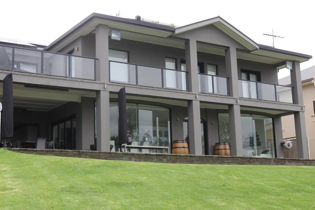 a large house with large windows and a lawn at River Devine in White Sands