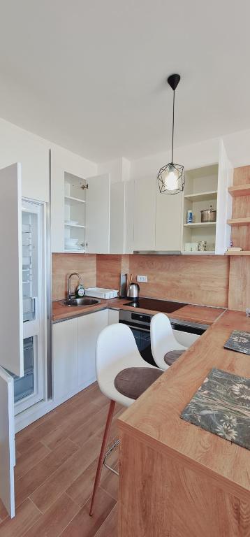 a kitchen with white cabinets and a table and chairs at SeaView Apartment & Pool in Ulcinj
