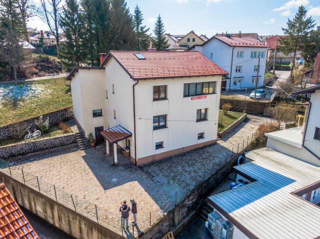 two people standing in front of a building next to a river at Apartments Krašna in Postojna