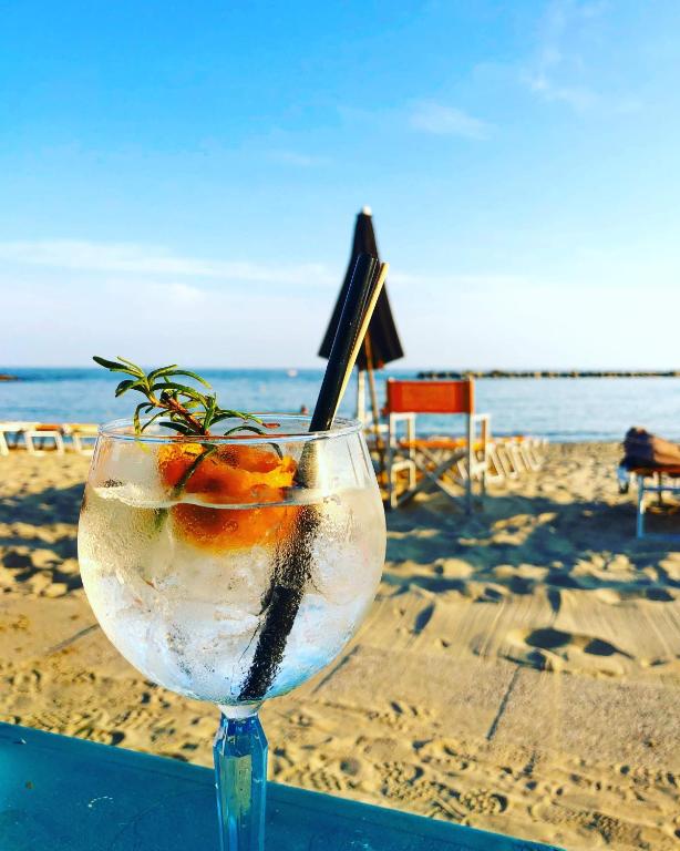 a drink in a glass on a table at the beach at Luxury Tugurio in Arma di Taggia