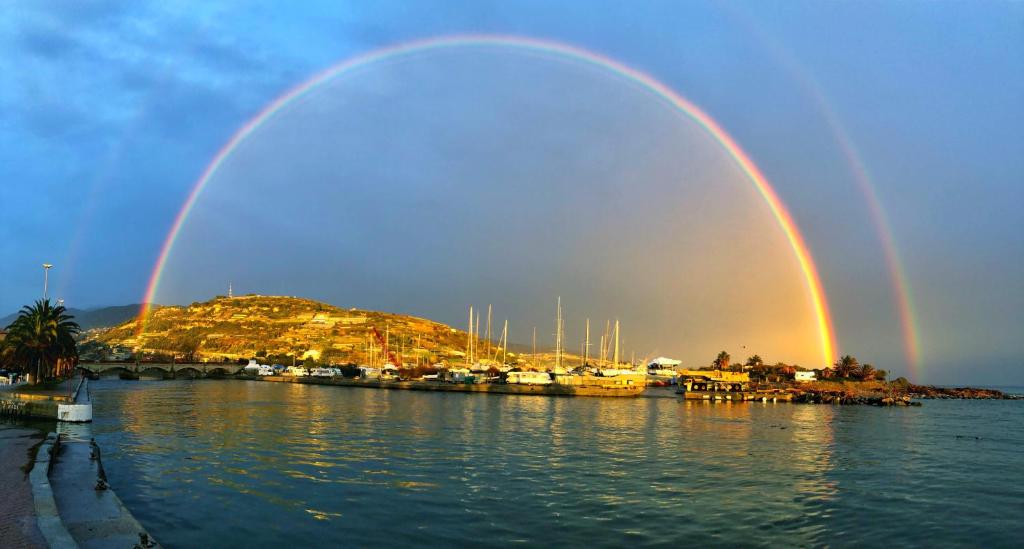 two double rainbow over a body of water with boats at Luxury Tugurio in Arma di Taggia