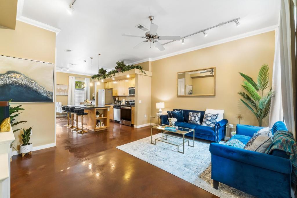 a living room with blue couches and a kitchen at Old East Hill Townhouse in Pensacola