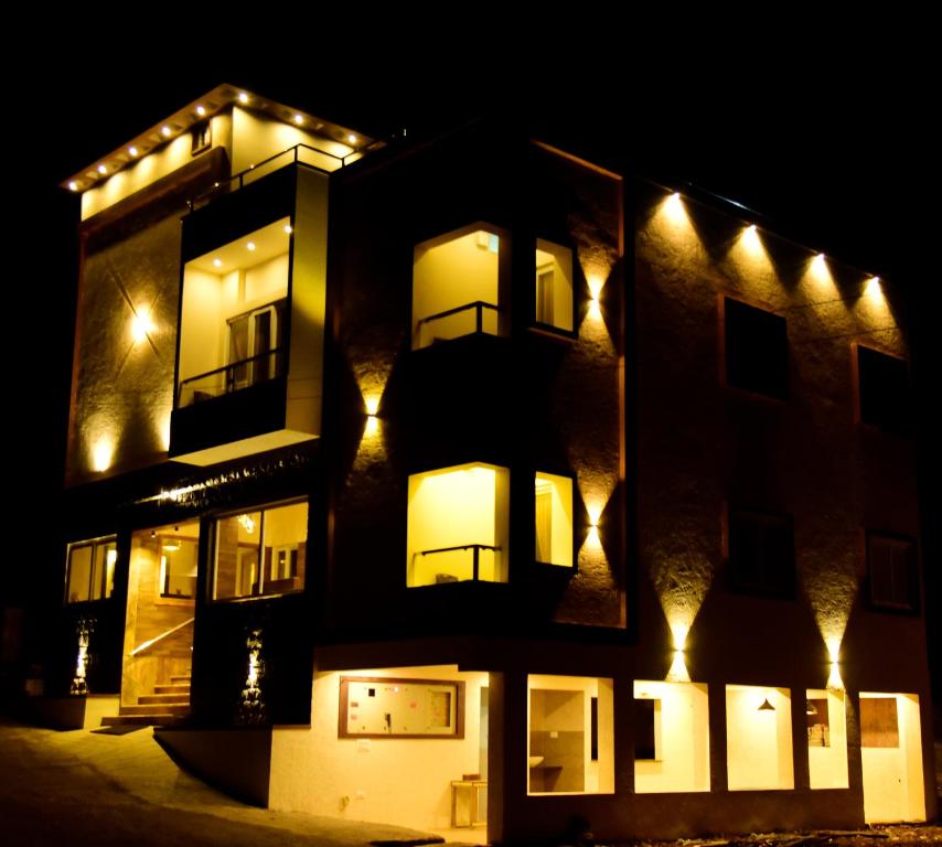 um edifício com luzes de lado à noite em Hotel R Inn Yercaud em Yercaud
