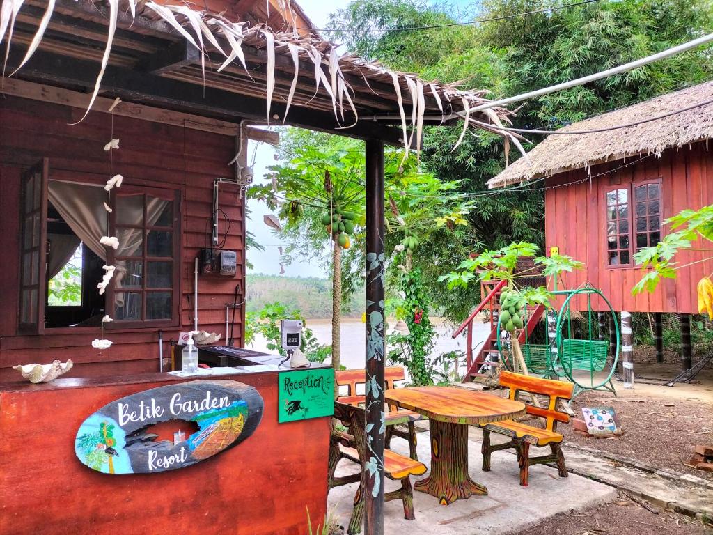 a table outside of a shack with a table and chairs at Betik Garden Home in Machang