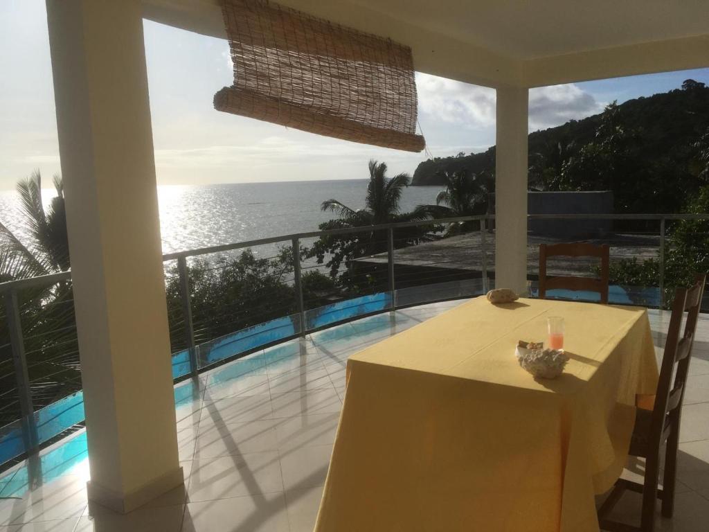 d'un balcon avec une table et une vue sur l'océan. dans l'établissement Suite Villa au bord de la mer chez Saloua, à Chirongui
