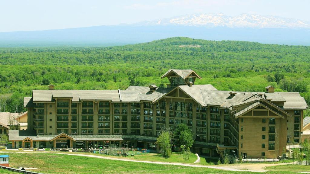 a large resort building with a mountain in the background at Wanda Jin Resort Changbaishan in Baishan