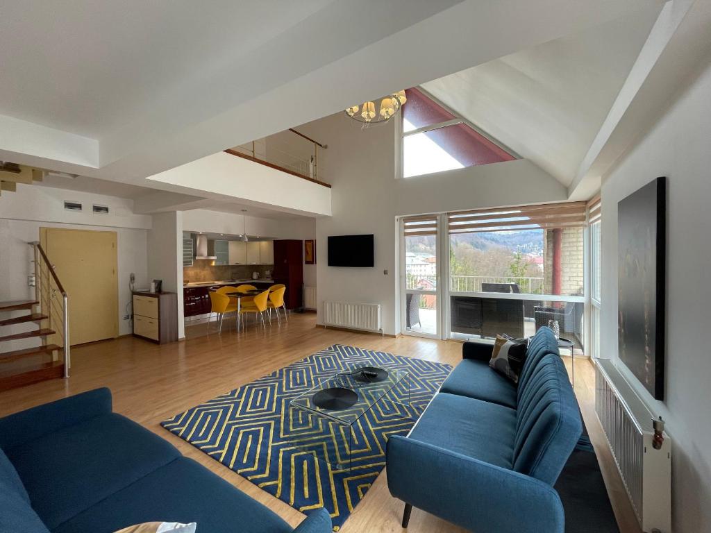 sala de estar con sofá azul y alfombra en Apartament Kyra Penthouse, en Sinaia